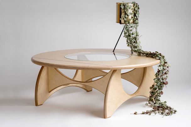 Viñas en forma de persona sentada en una mesa redonda de madera
 - Foto, imagen