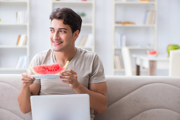 Man eating watermelon at home - Foto, afbeelding