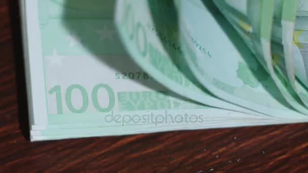 Stapel van honderd Euro-bankbiljetten op een tafel - Video