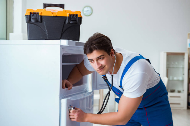 Repairman contractor repairing fridge in DIY concept - Фото, изображение