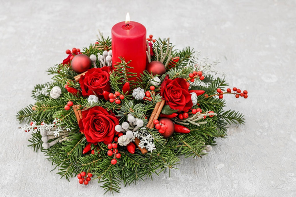 Christmas decoration with candle, red roses, fir, brunia and cin - Foto, Imagen