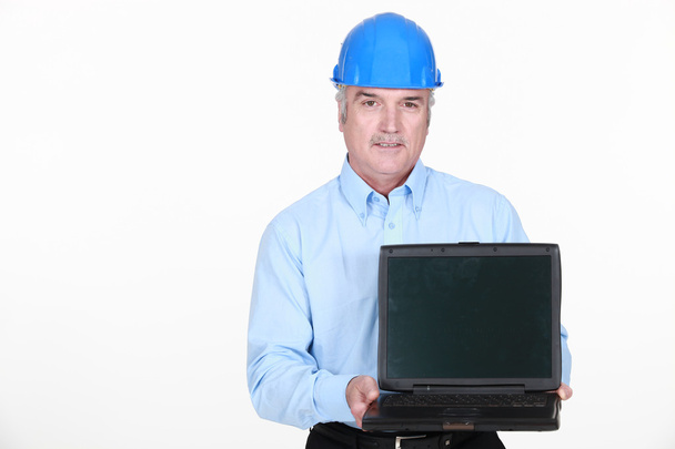 Architect stood holding portable computer - Foto, afbeelding