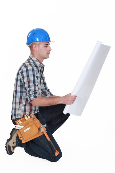 Worker examining building plans - Φωτογραφία, εικόνα