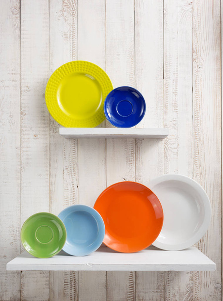 plate at kitchen shelf on wooden background - Фото, изображение