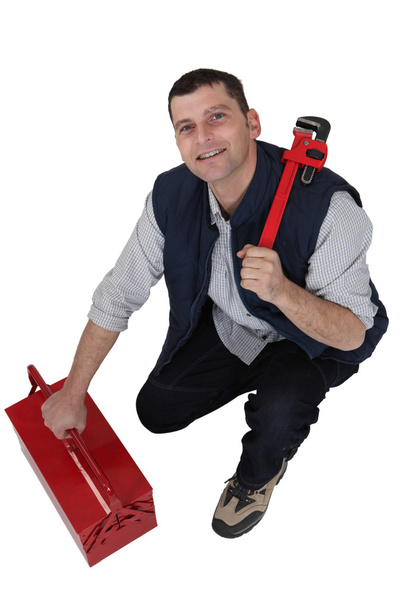 Tradesman with a pipe wrench and toolbox - Photo, Image