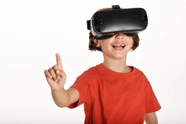 Little girl looking in VR glasses and gesturing with his hands. - 写真・画像
