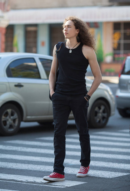 Outdoor portrait of modern young man walk street. Man with long curly hair. - Fotografie, Obrázek