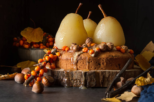 Autumn meal. Pie with pears, sea buckthorn and nuts. Dark backgr - Фото, зображення