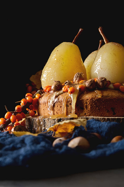 Autumn meal. Pie with pears, sea buckthorn and nuts. Dark backgr - Photo, Image