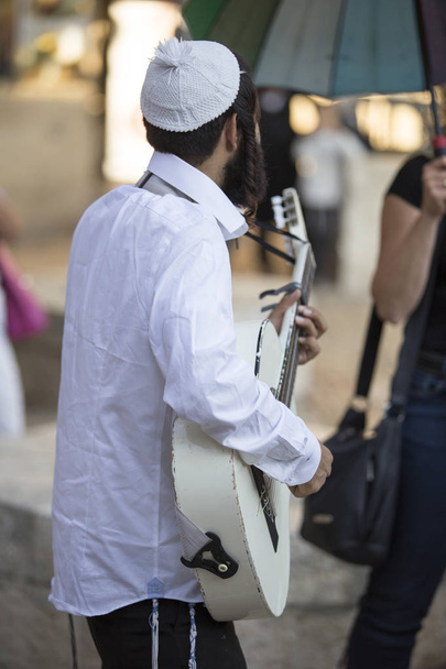 de dos, un homme au chapeau juif traditionnel et un shi blanc
 - Photo, image