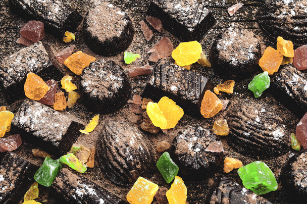 caramelos de chocolate, frutas confitadas sobre un fondo de madera
 - Foto, imagen
