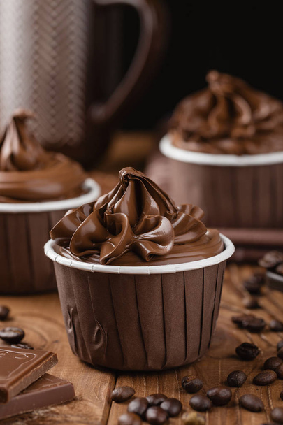 Homemade chocolate cupcakes on wooden background - Foto, afbeelding
