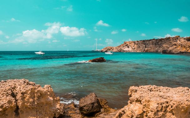 teal und orange Stimmung der Cala Tarida Strand mit Steinfelsen, Insel Ibiza. Spanien - Foto, Bild