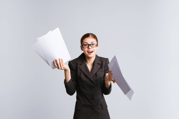 happy smart girl in a black suit and glasses holds documents in her hands and is happy - Foto, Imagen