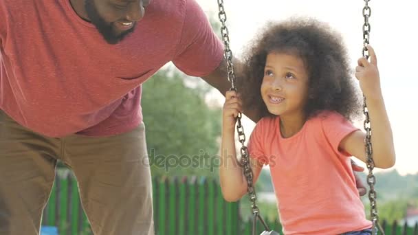 Fiatal apa, óvatosan lengő kis gyönyörű lánya, kertben, szerelem - Felvétel, videó