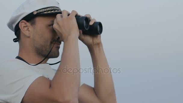 Homem olhando através de binóculos e polegar para cima
 - Filmagem, Vídeo