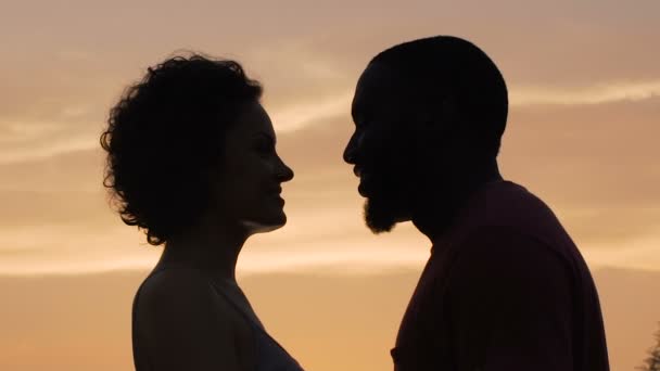 Silhouettes of man and woman gently touching each other, sunset background - Footage, Video