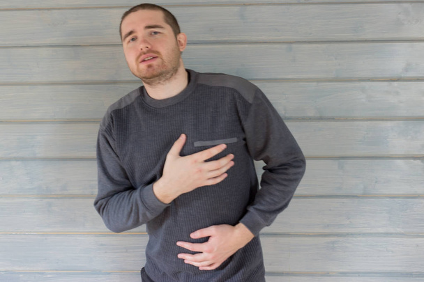 a man in a gray sweater hurts the heart.case of virus disease - Valokuva, kuva