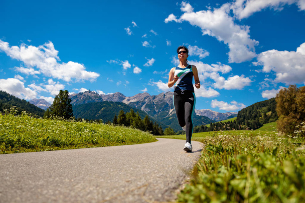 女性は屋外でジョギング。イタリア｜ドロマイト・アルプス - 写真・画像