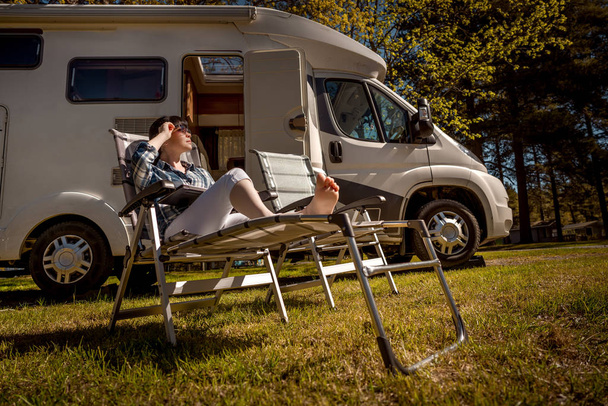 Woman resting near motorhomes in nature. Family vacation travel, - Foto, immagini