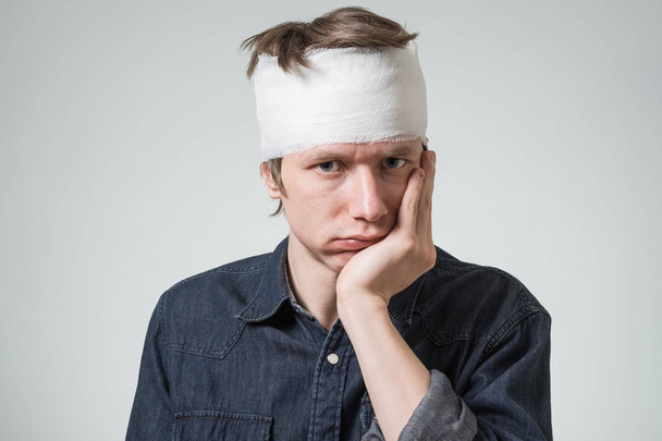 Man with bandage on his head - 写真・画像