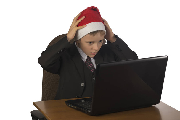 Junge mit Weihnachtsmann-Hut am Computer. - Foto, Bild