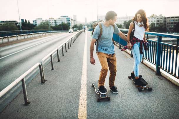 attractive couple riding skateboards  - Foto, imagen