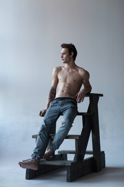 Shirtless male model on a ladder - Фото, зображення