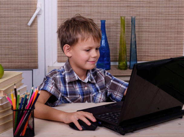 European boy at the table with books and laptop - Photo, Image