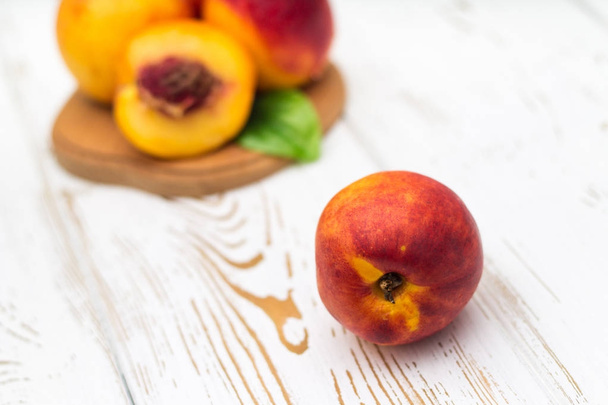 a lot of fresh peaches on a white table. - Foto, immagini
