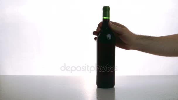 Man and woman put on desk bottle of red wine and glasses indoor. - Felvétel, videó