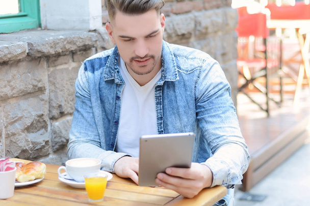 Young man in coffee shop cafe using a tablet.  - Photo, Image