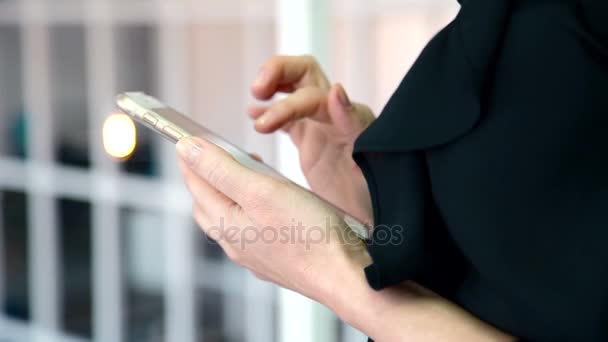 The lady in black blouse surfing the internet on her brand new smartphone. - Filmati, video