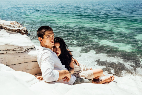 A young couple of lovers lies in beautiful clear water near white rocks on vacation - Foto, Imagem