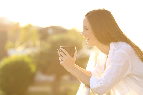 Home owner relaxing drinking coffee in a balcony - Foto, Imagem