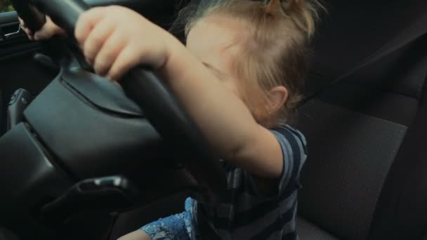 Baby driver, cute boy driving a car. Child holds the steering wheel. Driving school, road and travel with kid. On vacation by car. Transportation and safety, seat belt, baby car seat - Footage, Video