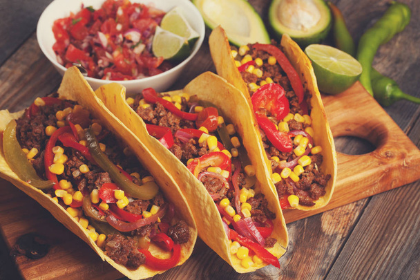 Mexican tacos with minced beef, vegetables and salsa. Tacos al pastor on wooden rustic background - Foto, Imagem
