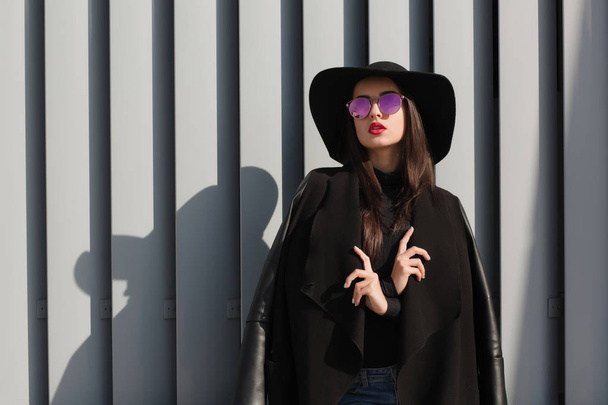 Уличный портрет модной молодой женщины в шляпе и очках
 - Фото, изображение
