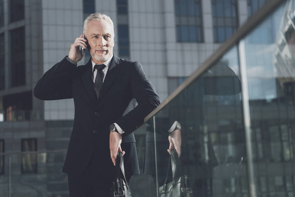 A respectable man with a beard in a business suit talking on the phone - 写真・画像