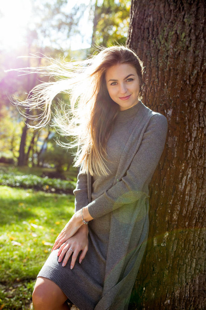 Романтична молода жінка носить сіре плаття, з волоссям у вітровій позі
  - Фото, зображення