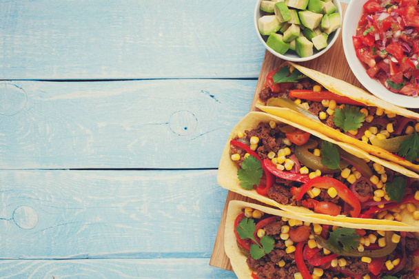 Tacos mexicanos con carne picada, verduras y salsa. Tacos al pastor sobre fondo rústico azul madera. Vista superior con espacio de copia
 - Foto, Imagen
