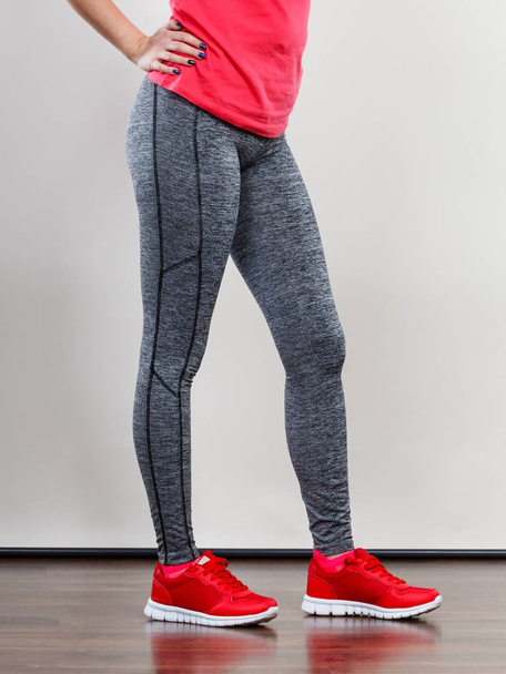 Woman wearing sportswear standing on weight machine - Фото, изображение