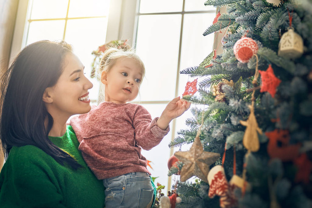 Mom and daughter decorate Christmas tree - Photo, image