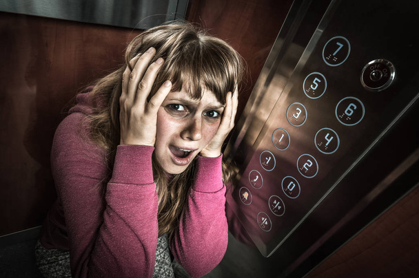 Shocked woman with claustrophobia in the moving elevator - Photo, Image