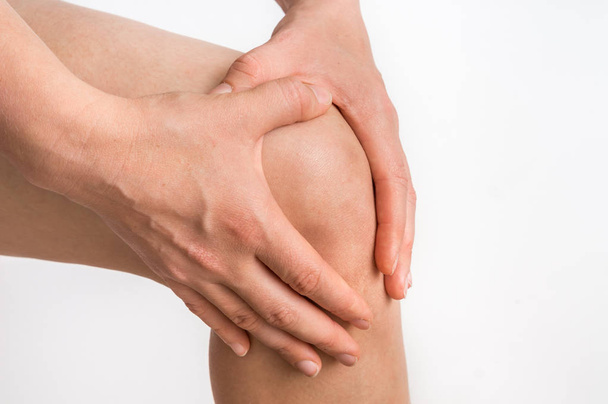Mujer con dolor de rodilla sostiene su pierna dolorida
 - Foto, imagen