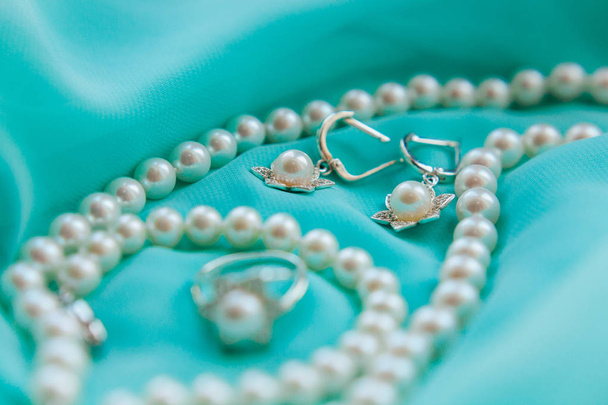 Pearl necklace, earrings and ring on luxury satin background - Photo, Image