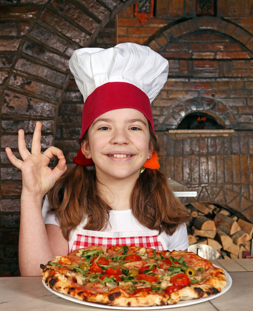 mutlu küçük kız yemek pizza lokanta ve ok el işareti ile - Fotoğraf, Görsel