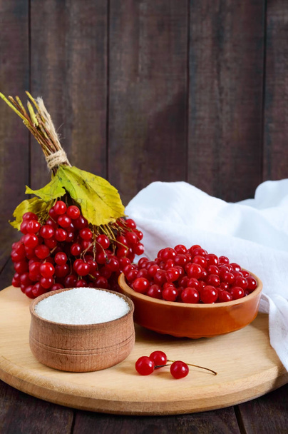 Red viburnum in a ceramic bowl, sugar, a bunch of berries for tea, jam. - Photo, Image