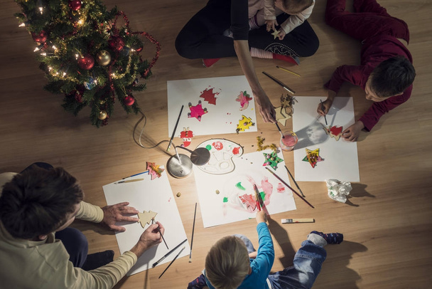 Top view of a family with two kids and a baby making Christmas d - Zdjęcie, obraz