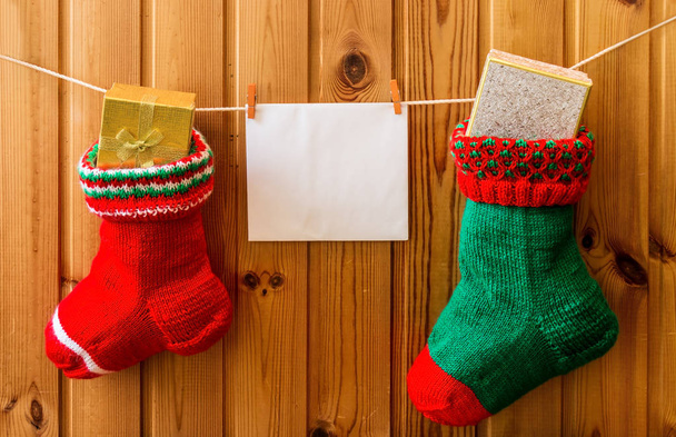 Christmas stockings and greeting card on wooden wall - Fotografie, Obrázek
